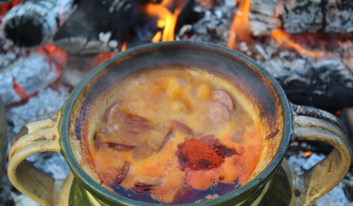 Tradicionalni baranjski čobanac, bogato začinjeni gulaš od mesa, poslužen u rustikalnoj zdjeli s domaćim kruhom uz bok.